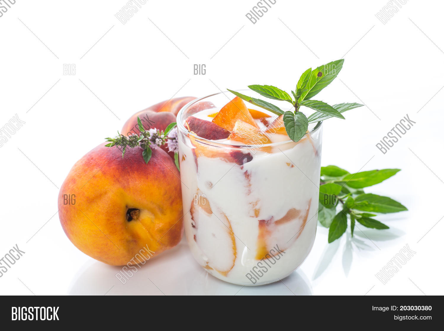 sweet home-made yogurt with pieces of peach in a glass cup