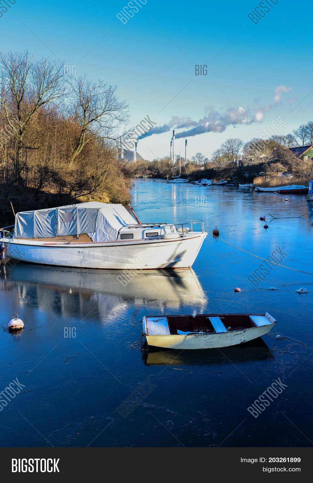 two small boats locked on an icy river in the winter