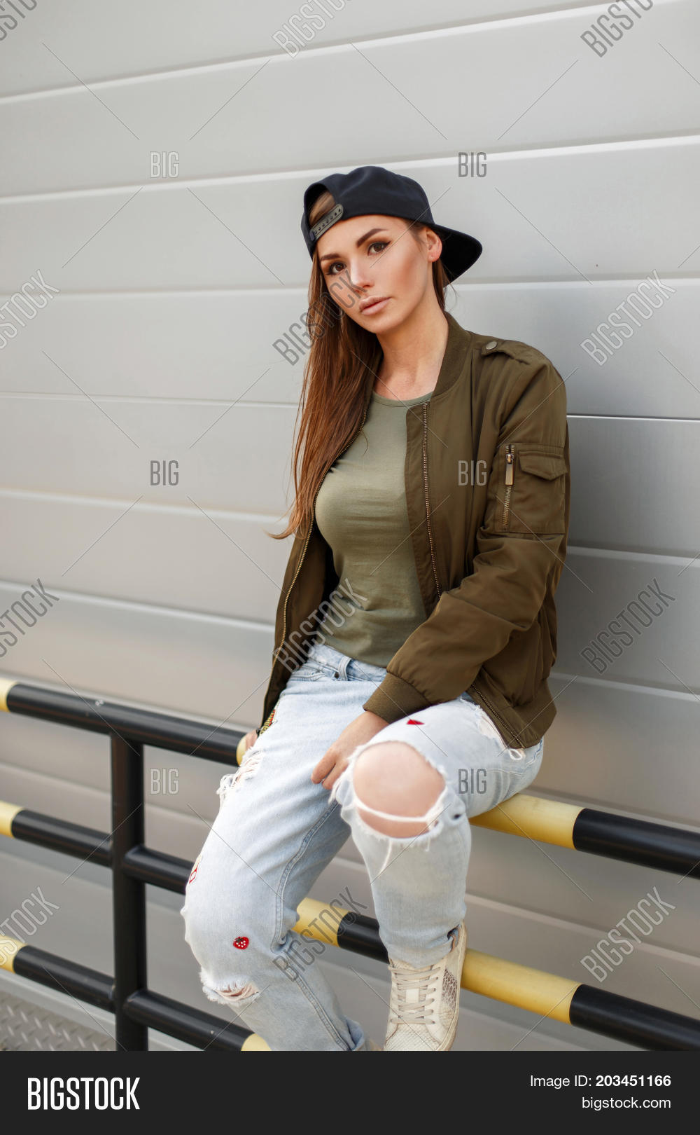 young beautiful girl with freckles in a baseball cap in a street