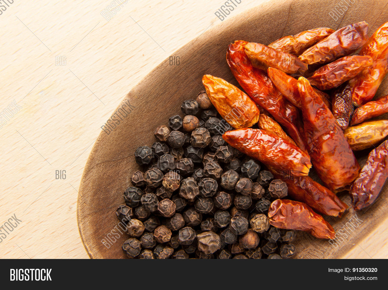 hot spices: black peppercorn and dried chili peppers on a wooden