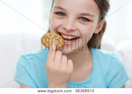food, sweets and bakery concept - smiling little girl eating