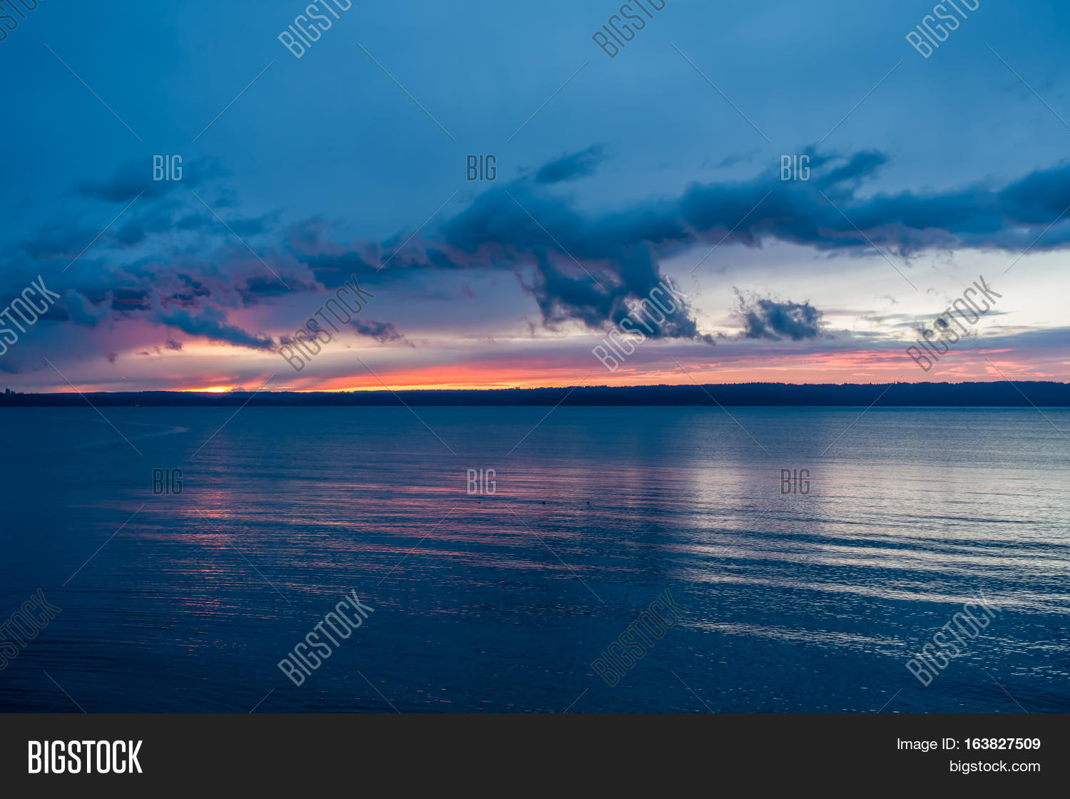 the sun sets behind the puget sound in winter.