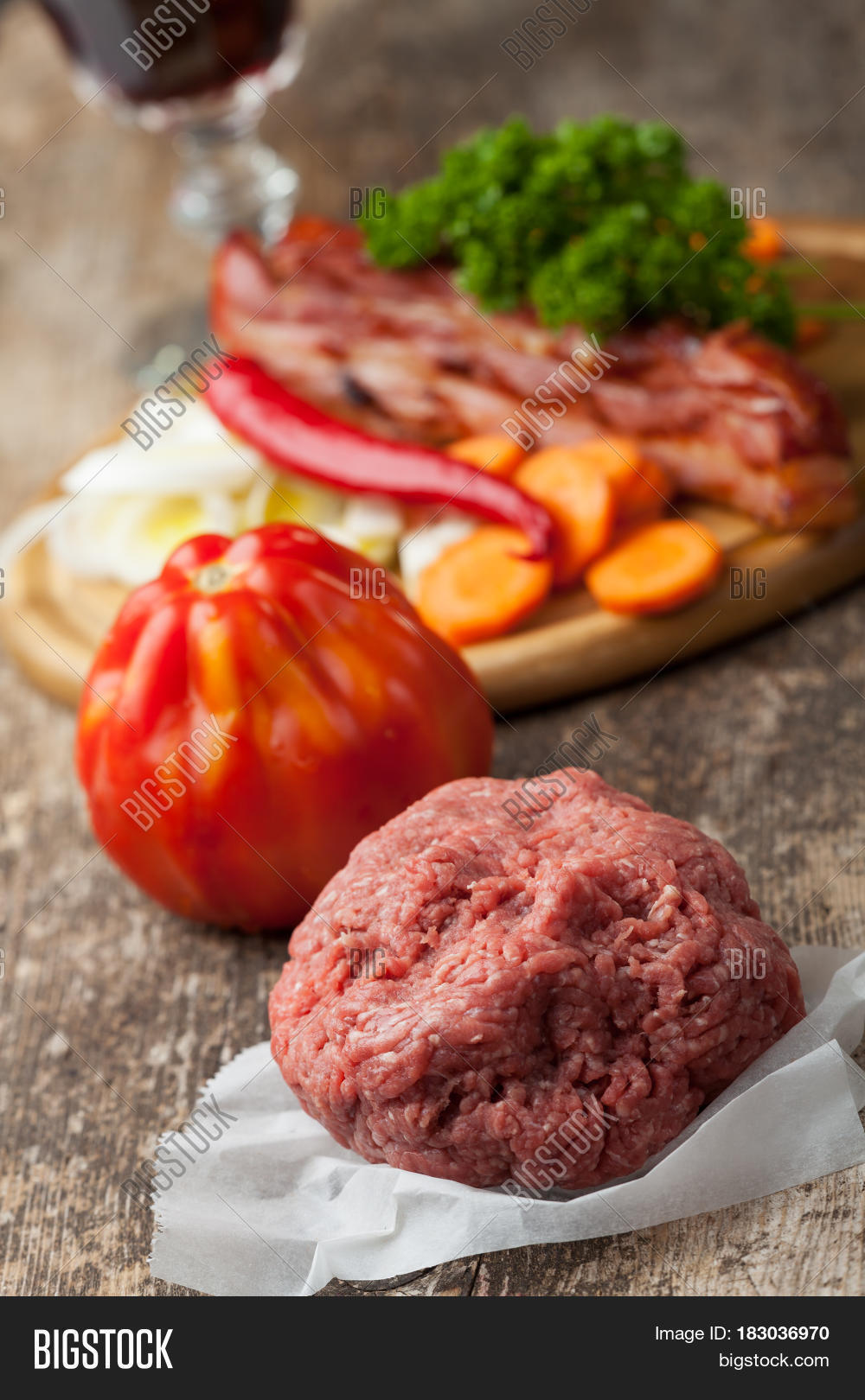 raw minced meat and ingredients on wood