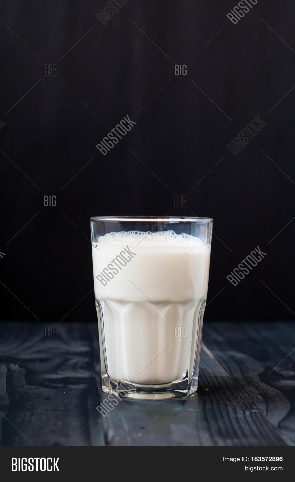 a glass of milk on a dark background.