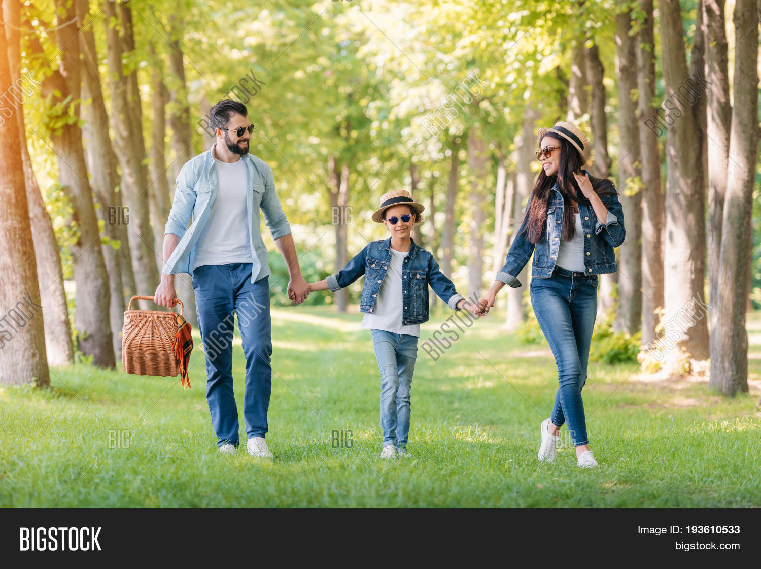 young interracial family with picnic basket spending time
