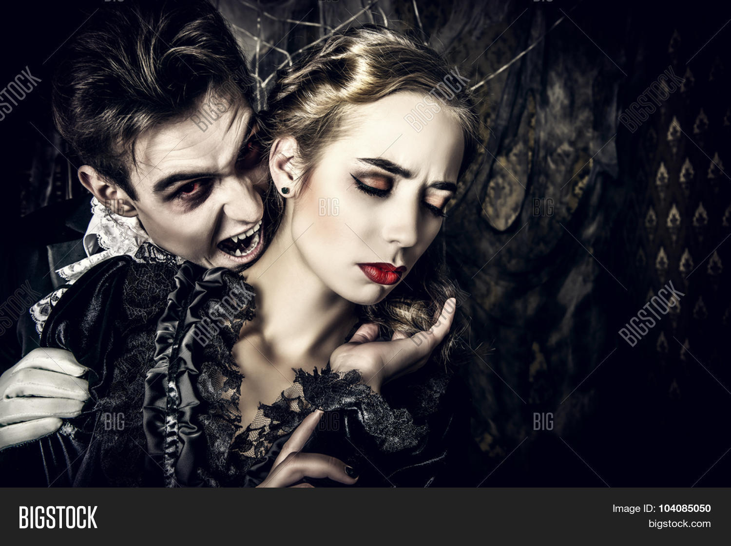 bloodthirsty male vampire in medieval dress is biting a