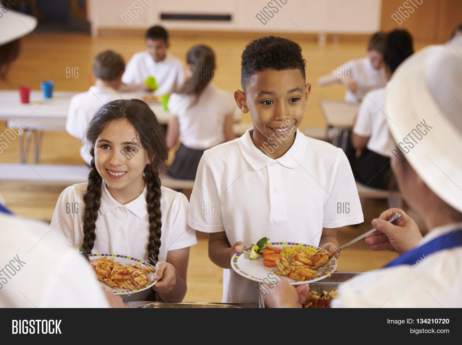 over shoulder view of kids being served in school cafeteria