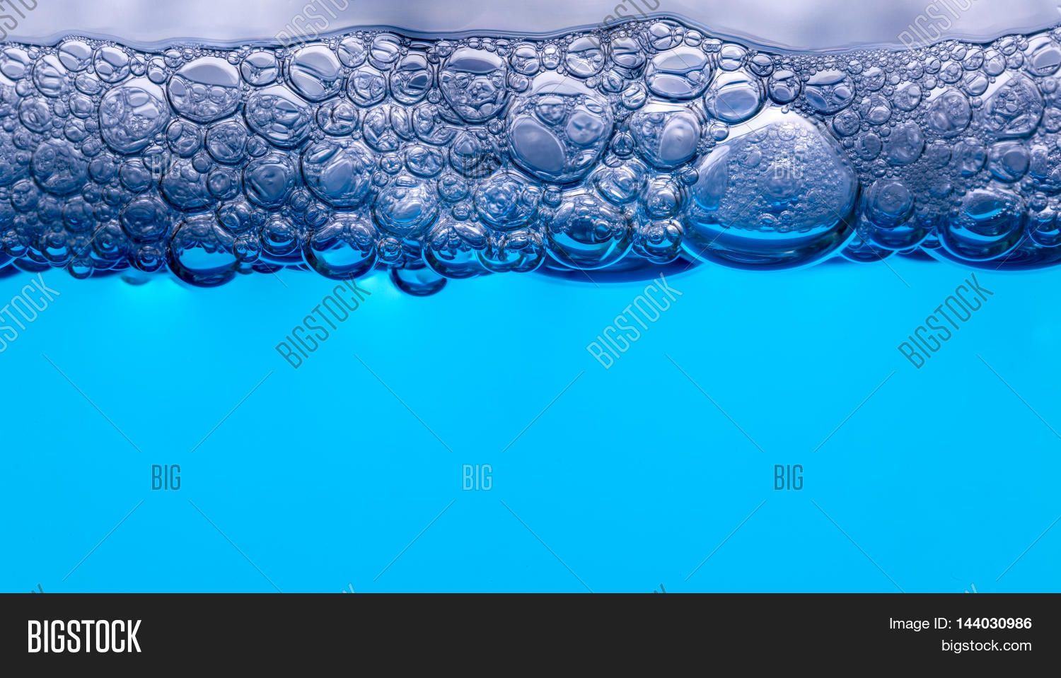 strip of air bubbles at water surface closeup.