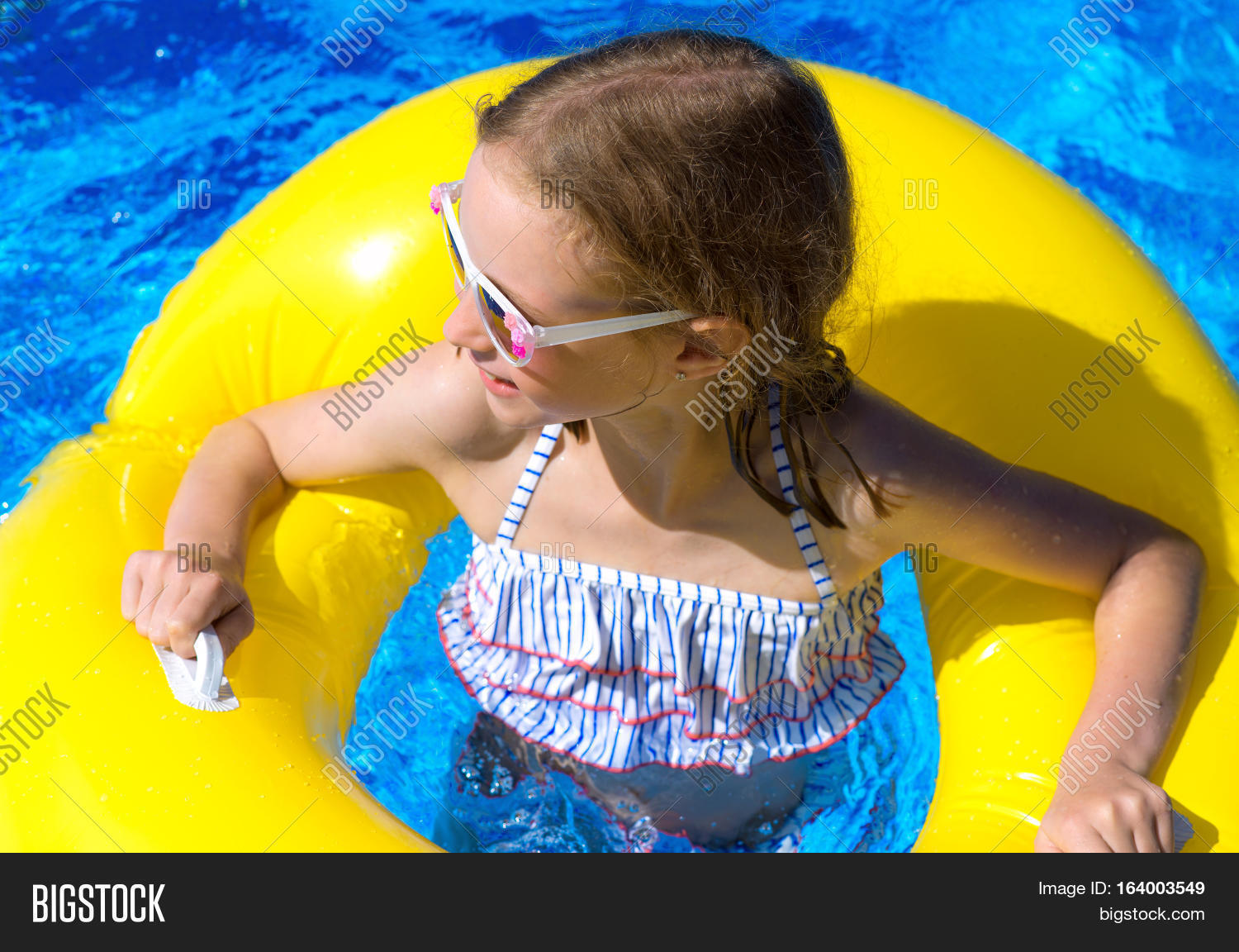 portrait of little girl with inflatable rubber ring in swimming
