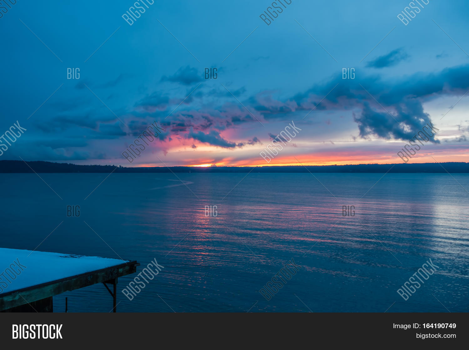 the sun sets behind the puget sound in winter.
