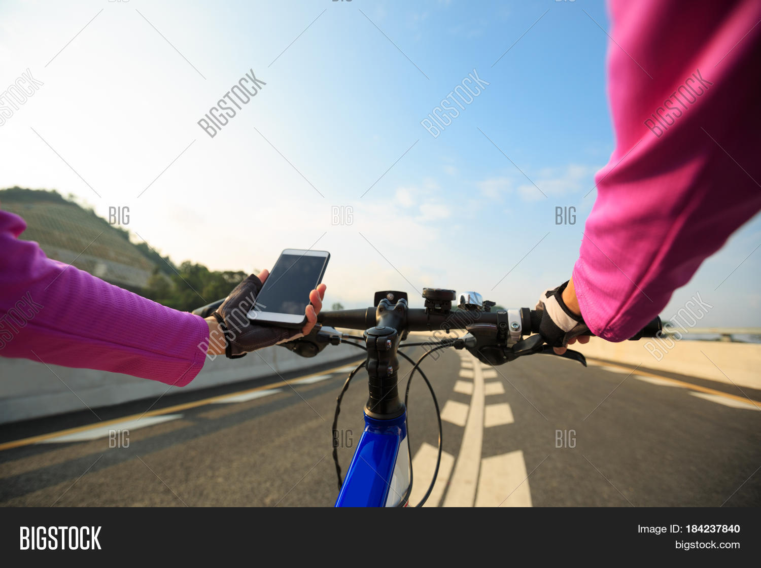 cyclist hands use smartphone cycling on high way