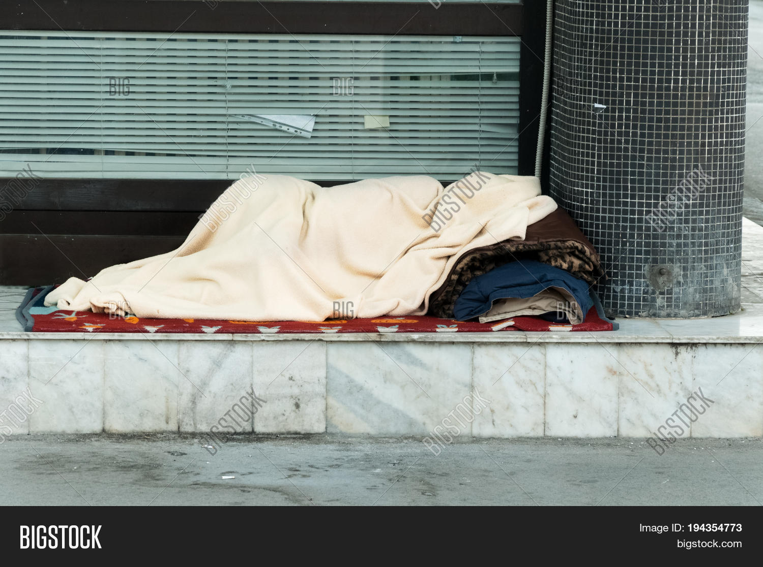 poor homeless person, covered with a blanket, sleep in the