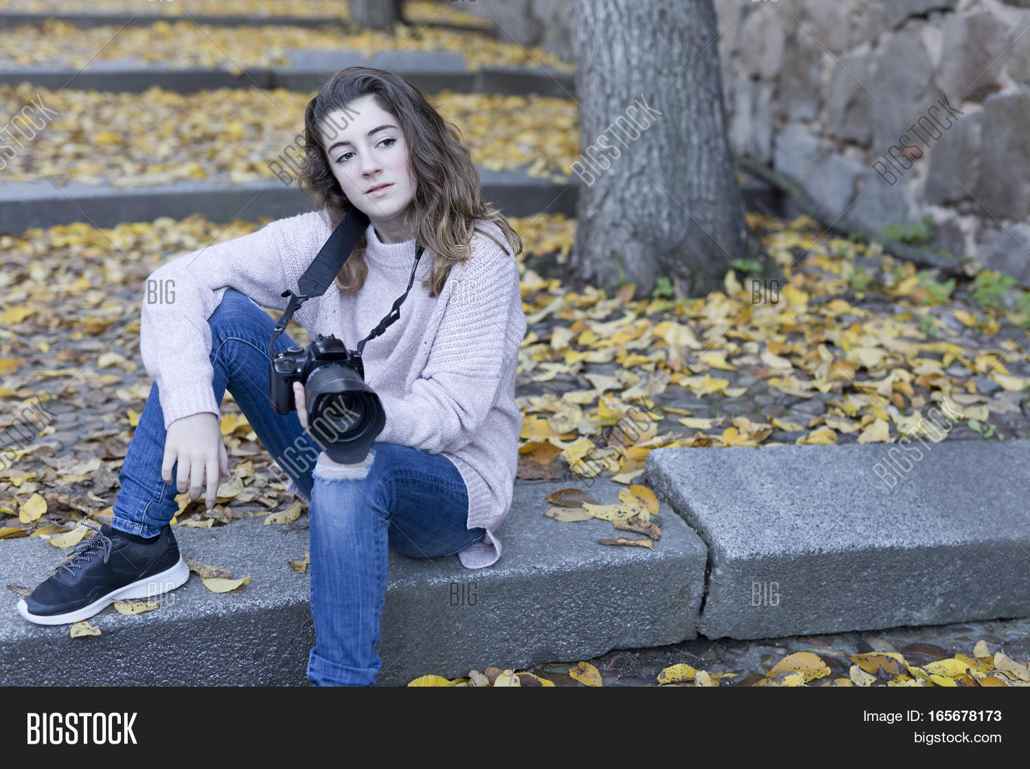 young woman taking photos by the old town of toledo spain.