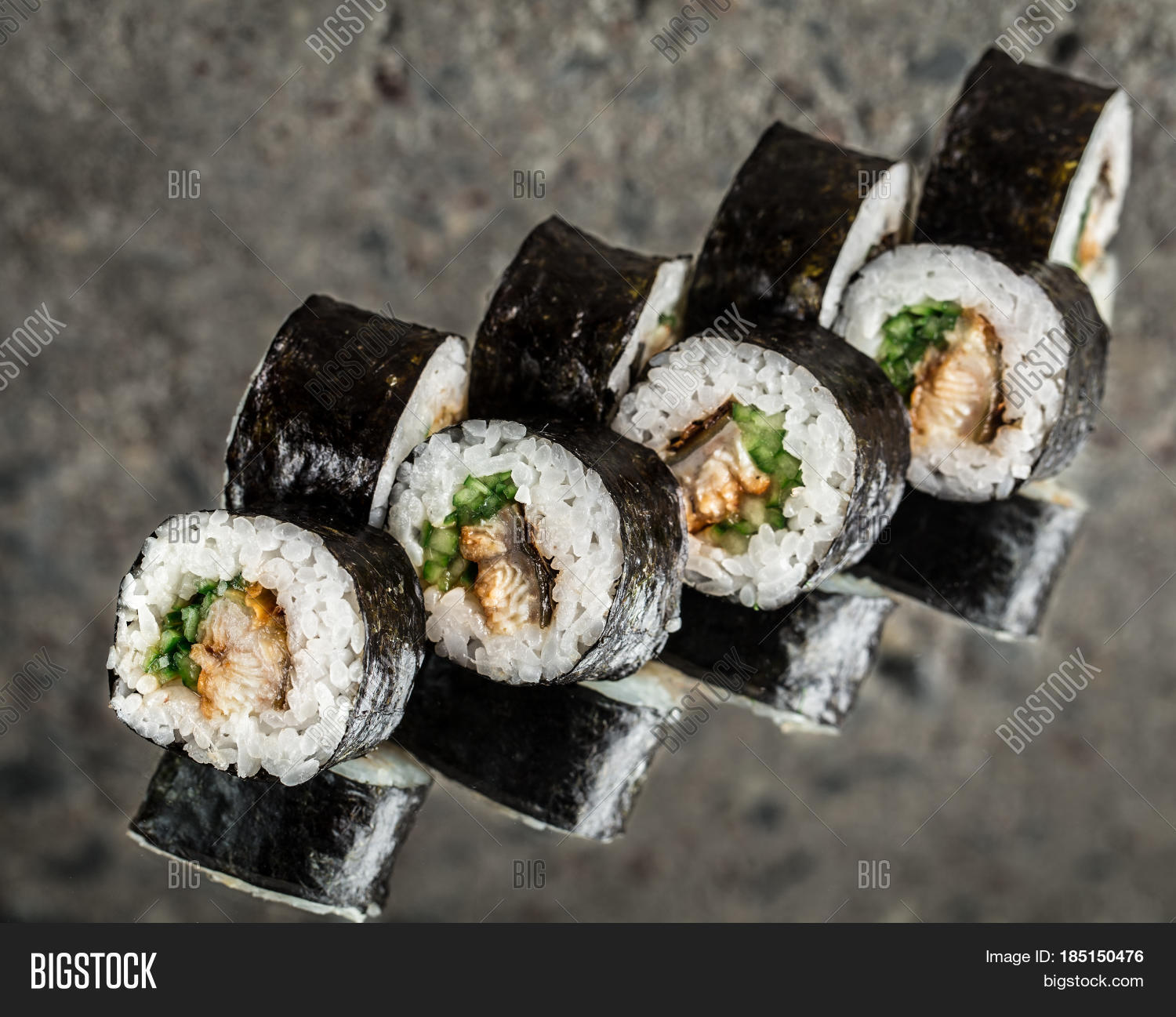 sushi roll with eel and cucumber over cocnrete background