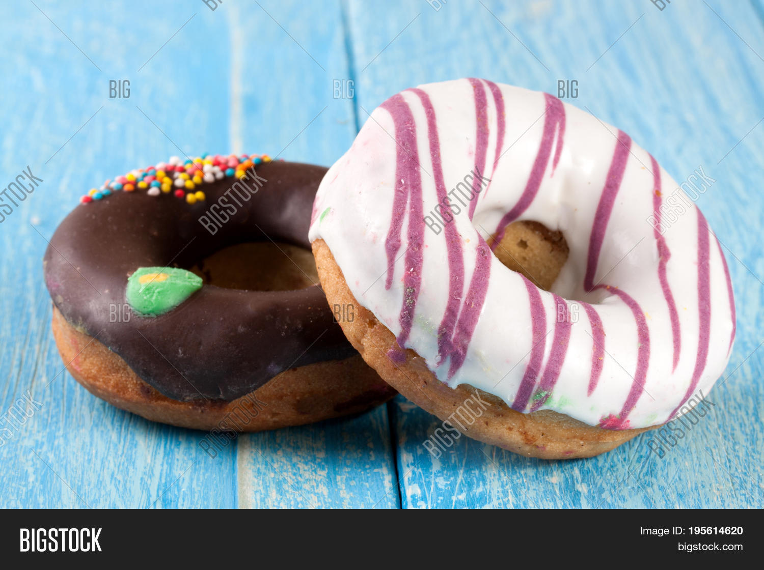 two glazed donut on blue wooden background.