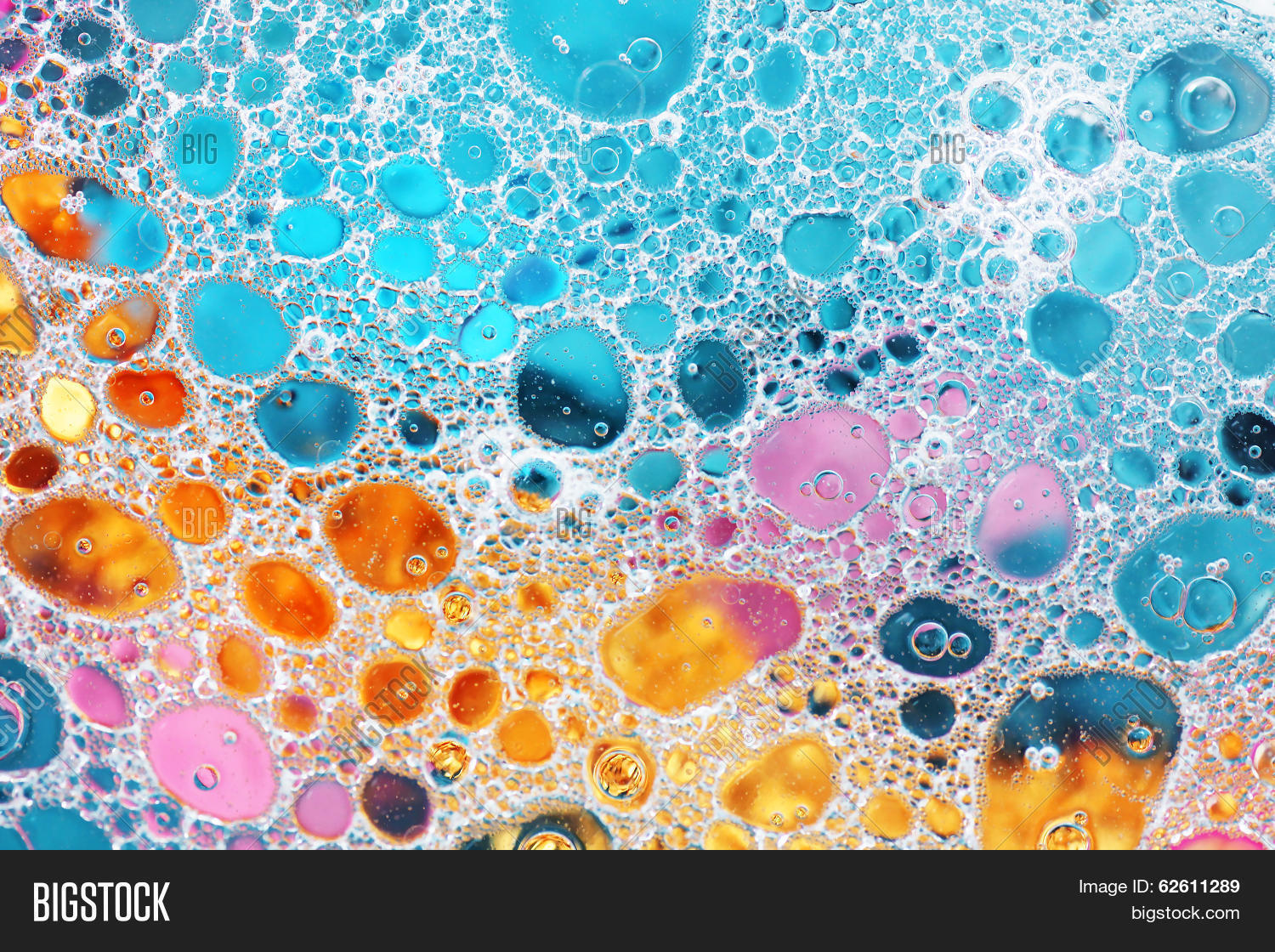 oil drop and water over colorful pink gold and blue background