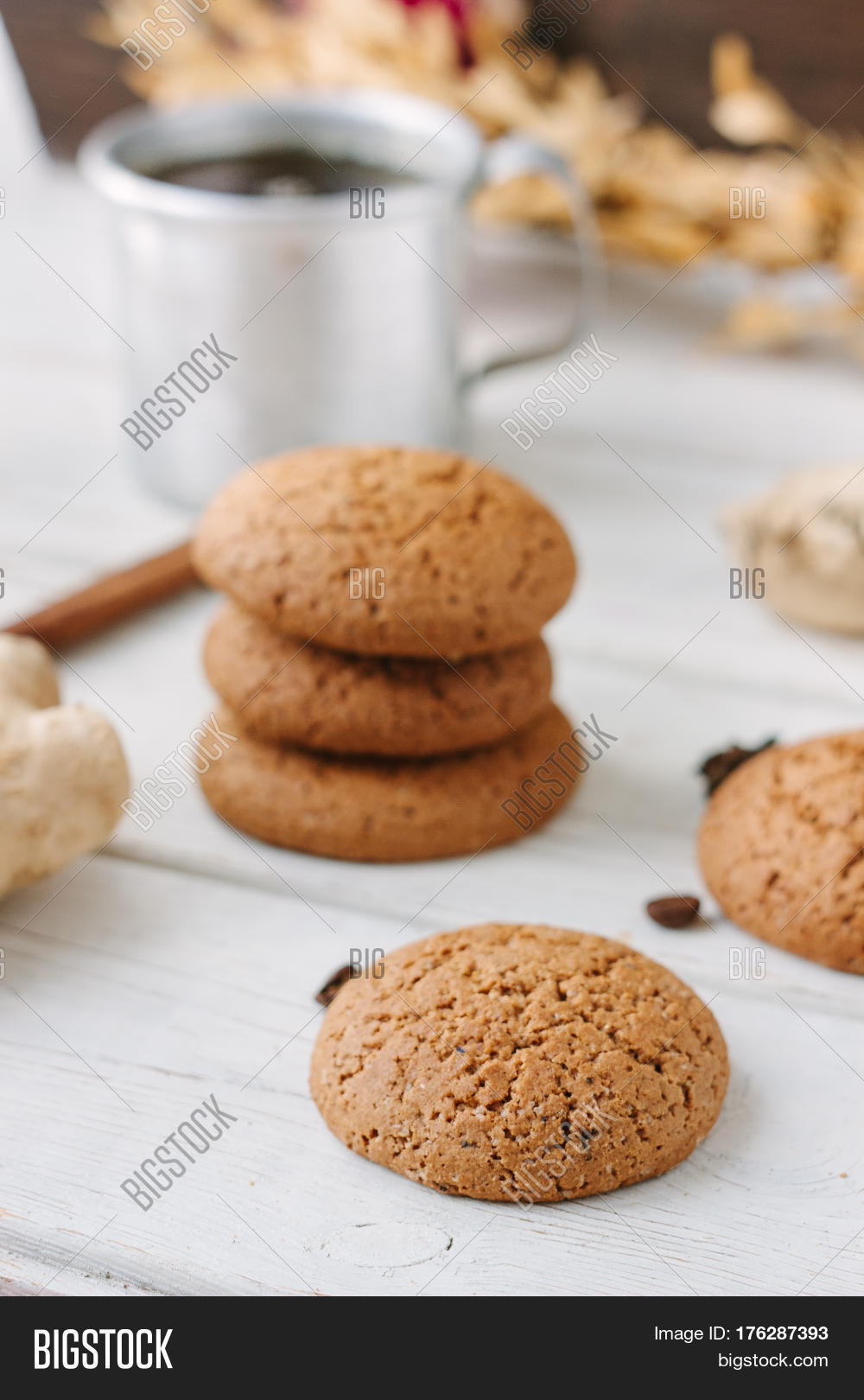 ginger snaps on white wooden surface with spices around.