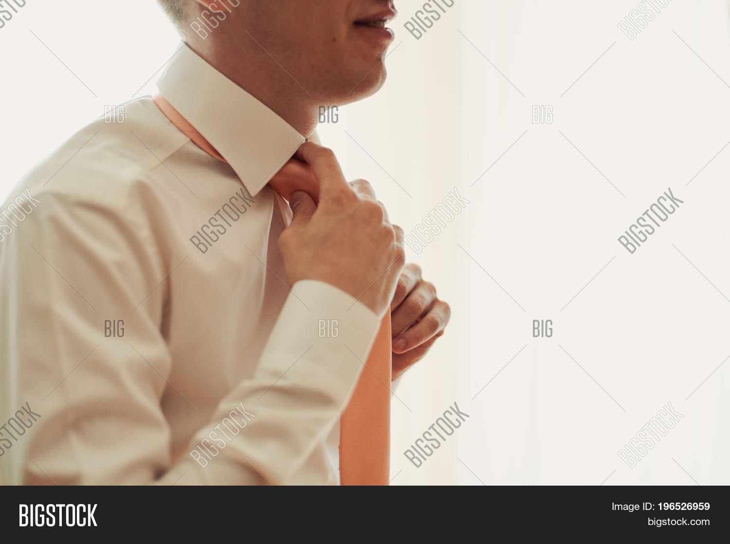 the groom in a suit corrects a tie. grooms accessories