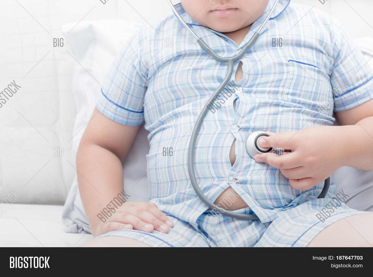 obese fat boy check stomach by stethoscope.