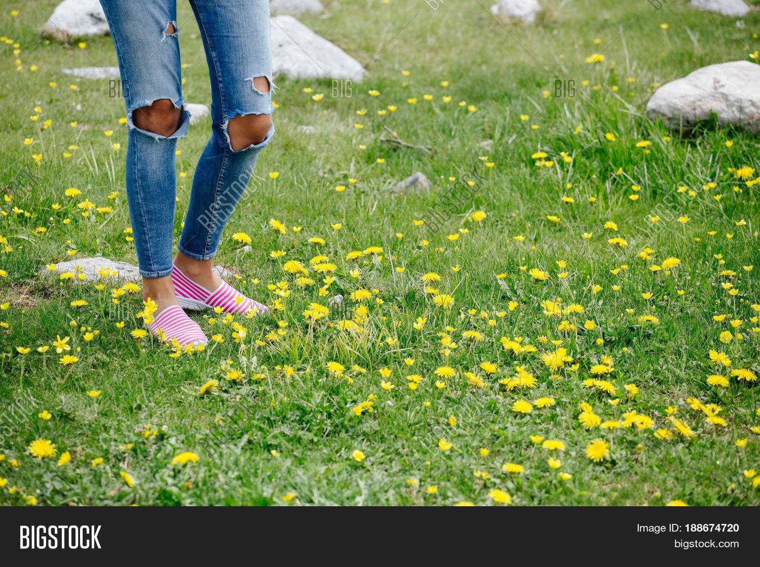 woman legs walk on green grass.