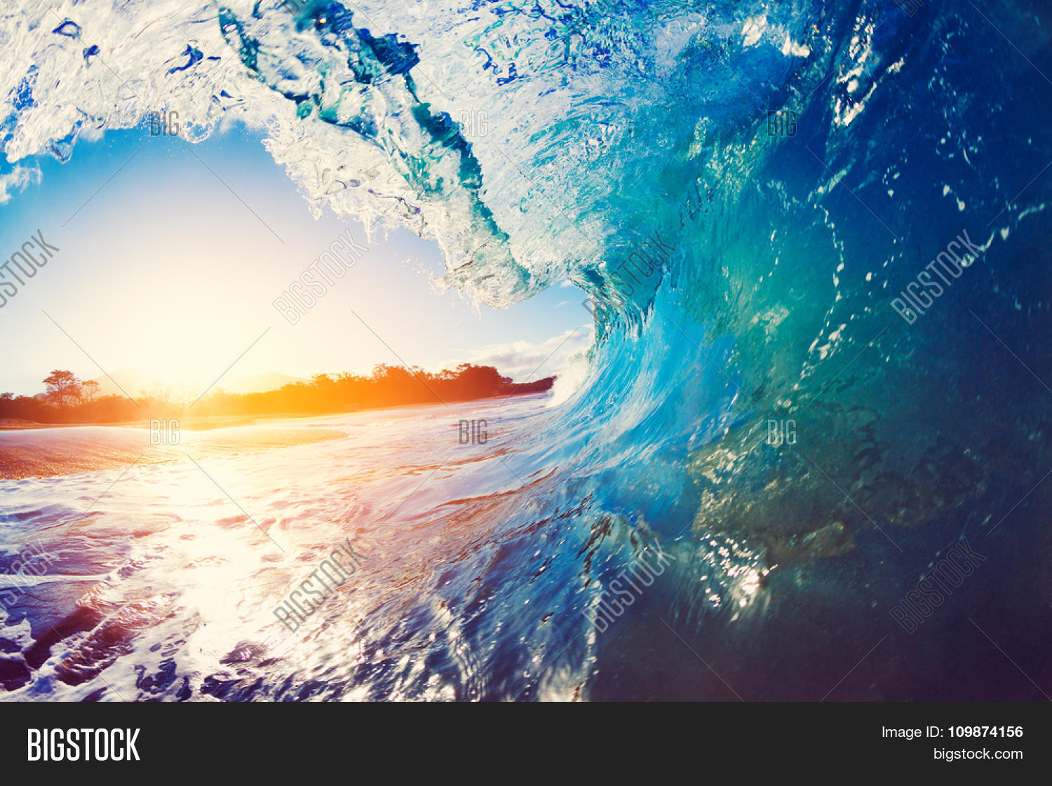 blue ocean wave crashing at sunrise