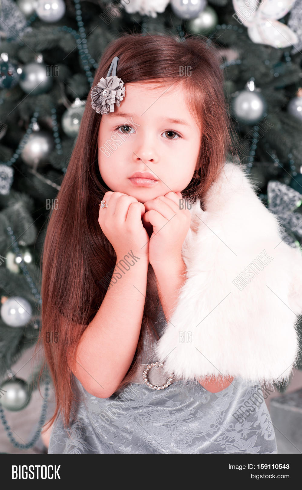 baby girl 4-5 year old posing in room over christmas tree with