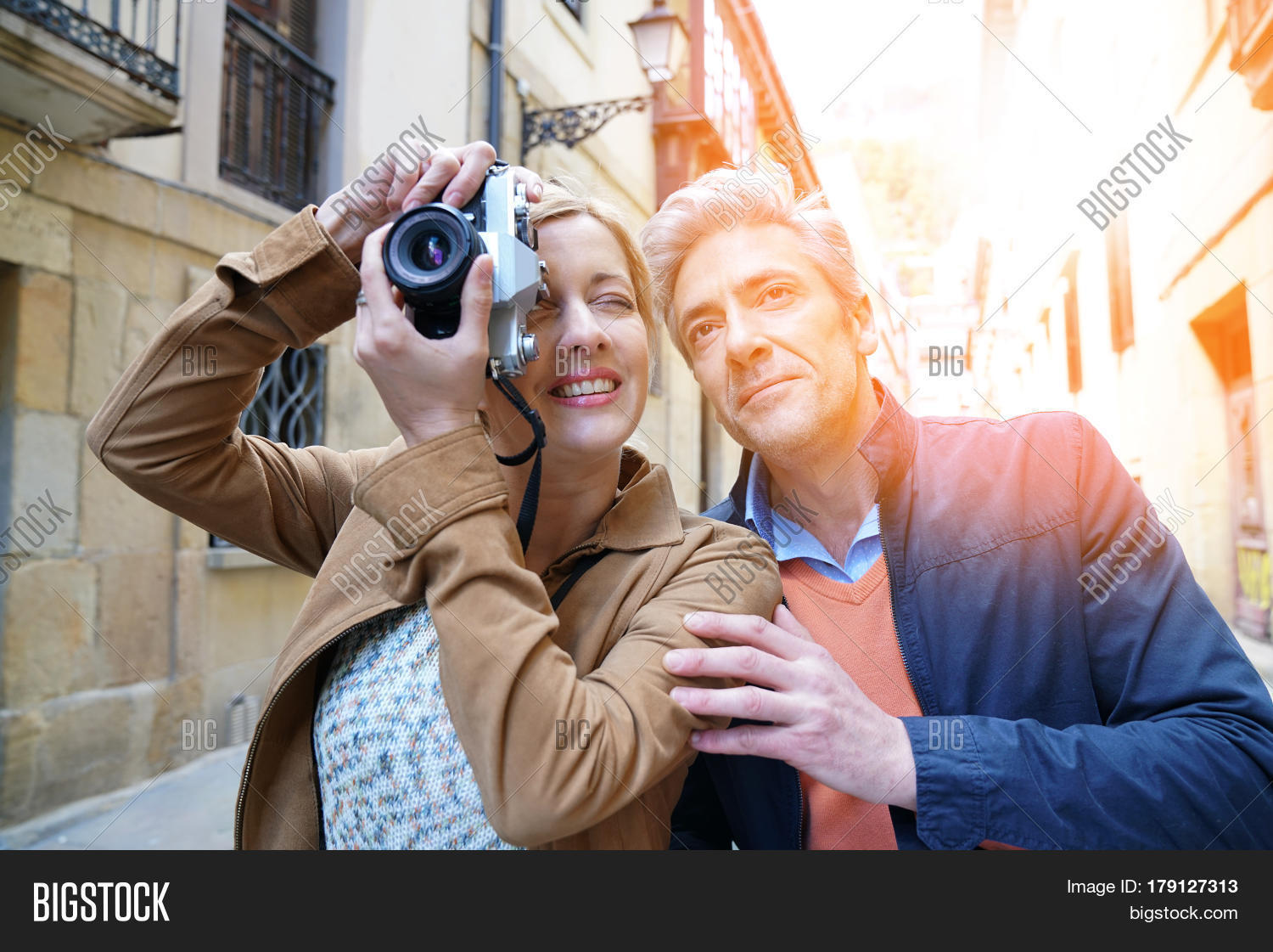 couple of tourists taking pictures of old quarter building