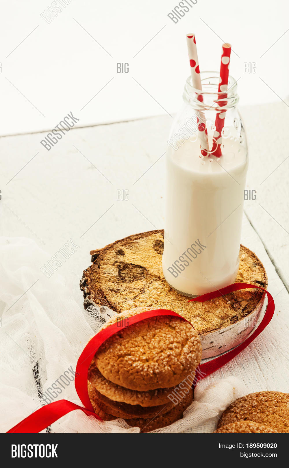 a stack of round shortbread cookies and a bottle of milk on a